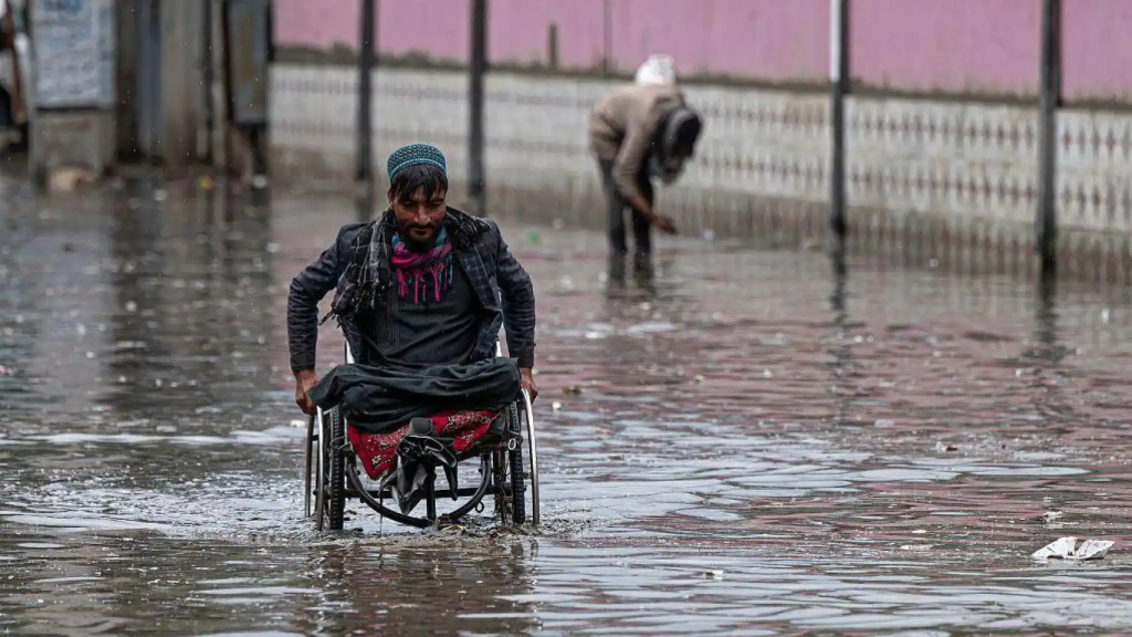 Imagen que muestra a una persona en silla de ruedas tratándo de avanzar en una inundación