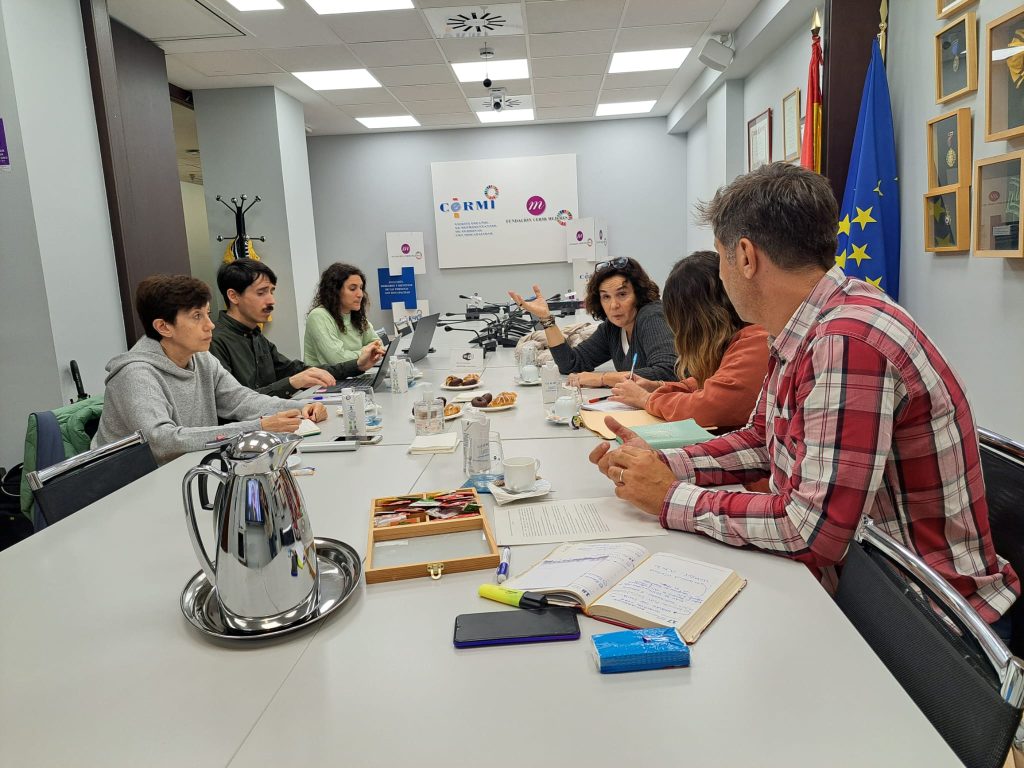 Participantes de la Asamblea de la Plataforma DESC España en torno a una mesa de trabajo